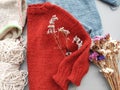 Knitter`s table with unfinished baby sweaters