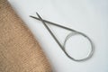 Knitting beige fabric on a white background with knitting steel needles. Copyspace. For for yarn stores, needlework, banner design