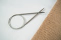 Knitting beige fabric on a white background with knitting steel needles. Copyspace. For for yarn stores, needlework, banner design