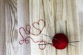 Knitting concept. Wool ball and heart shaped thread on wooden background Royalty Free Stock Photo