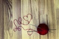 Knitting concept. Wool ball and heart shaped thread on wooden background Royalty Free Stock Photo