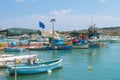 Knitting fishing nets and boats in harbour of Marsaxlokk, Malta Royalty Free Stock Photo