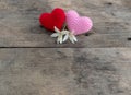 Red snd pink nitting hearts with flowers on wooden table Royalty Free Stock Photo