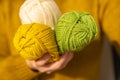 Knitting hobby.Skeins of yarn of various colors beige colour in hands in a in a mustard wool sweater.Wool yarn in yellow Royalty Free Stock Photo