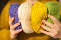 Knitting hobby.Skeins of yarn of various colors in hands in a in a mustard wool sweater.Wool yarn in yellow, beige Royalty Free Stock Photo