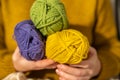 Knitting hobby.Skeins of yarn of various colors in hands in a in a mustard wool sweater.Wool yarn in yellow, beige Royalty Free Stock Photo