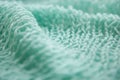 Knitting menthol or green textured wool background, close up of wrinkled fabric