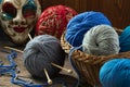 Knitting needles, wool balls and carnival mask on a wooden table Royalty Free Stock Photo