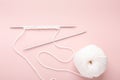 Knitting project in progress. White knitting wool and knitting needles on pastel pink background. Female hobby knitting Royalty Free Stock Photo