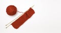 Knitting. Red ball of yarn with spokes on a white background, free space for text Royalty Free Stock Photo