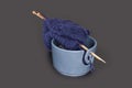 Knitting tools, ball of wool yarn for knitting and wooden needles. Blue yarns in a bowl isolated on dark gray background table. Royalty Free Stock Photo