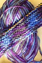 Knitting on wooden knitting needles from violet blue purple yarn close-up. Hobby, homemade Royalty Free Stock Photo