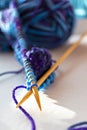 Knitting on wooden knitting needles from violet blue purple yarn close-up. Hobby, homemade Royalty Free Stock Photo