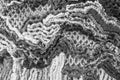Knitting from woolen threads is a worthy hobby with a beautiful result, close-up, black and white image.