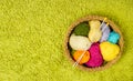 Knitting yarn balls, needles in basket over green carpet back Royalty Free Stock Photo