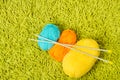 Knitting yarn balls and needles over green carpet Royalty Free Stock Photo