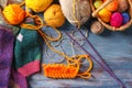 Knitting yarn with needles and clothes on wooden table Royalty Free Stock Photo