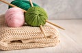 Knitting yarn with needles and scarf on wooden table Royalty Free Stock Photo