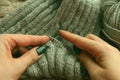 Knitting - young womans hands using knitting needles and grey wool roll. woman hands knitting Royalty Free Stock Photo