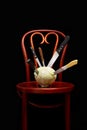 Knives stuck on a white cabbage put on a Thonet chair