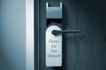 A knob of a hotel door with `Please do not disturb` tag