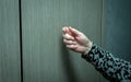 A knock on the door of an elderly woman, a woman's hand knocks on a wooden door Royalty Free Stock Photo