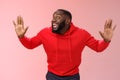 Knock who there. Charming happy funny black bearded guy bending towards camera raised palms move like mime act pressed Royalty Free Stock Photo