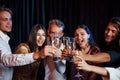 Knocking glasses. Group of friends in festive clothes have party indoors together