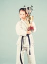 Knockout. energy activity for kids. small girl with champion cup. martial arts. practice Kung Fu. happy childhood. sport