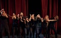 Knot in the hands. Group of actors in dark colored clothes on rehearsal in the theater Royalty Free Stock Photo