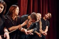 Knot in the hands. Group of actors in dark colored clothes on rehearsal in the theater Royalty Free Stock Photo