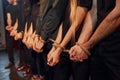 Knot in the hands. Group of actors in dark colored clothes on rehearsal in the theater Royalty Free Stock Photo