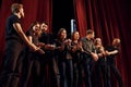 Knot in the hands. Group of actors in dark colored clothes on rehearsal in the theater Royalty Free Stock Photo