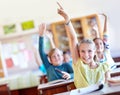 We know the answer. A group of school children raising their hands in class. Royalty Free Stock Photo