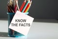 KNOW THE FACTS - inscription on notepad next to colored pencils