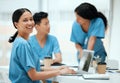 Always in the know about new medical developments. a young female doctor using a laptop while working at a hospital. Royalty Free Stock Photo