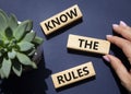 Know the rules symbol. Wooden blocks with words Know the rules. Beautiful deep blue background with succulent plant. Businessman Royalty Free Stock Photo