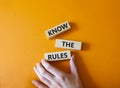 Know the rules symbol. Wooden blocks with words Know the rules. Beautiful orange background. Businessman hand. Business and Know Royalty Free Stock Photo