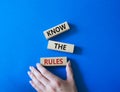 Know the rules symbol. Wooden blocks with words Know the rules. Beautiful blue background. Businessman hand. Business and Know the Royalty Free Stock Photo