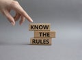Know the rules symbol. Wooden blocks with words Know the rules. Beautiful grey background. Businessman hand. Business and Know the Royalty Free Stock Photo