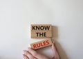 Know the rules symbol. Wooden blocks with words Know the rules. Beautiful white background. Businessman hand. Business and Know Royalty Free Stock Photo