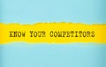 KNOW YOUR COMPETITORS text on the torn paper , yellow background Royalty Free Stock Photo