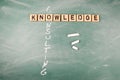 Knowledge and Consulting. Wooden alphabet letters on a green chalk board Royalty Free Stock Photo