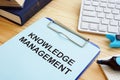 Knowledge management. Clipboard and books on table Royalty Free Stock Photo