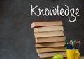 Knowledge text on blackboard with stack of books on desk Royalty Free Stock Photo