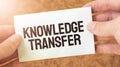 KNOWLEDGE TRANSFER word inscription on white card paper sheet in hands of a businessman. recap concept. red and white paper Royalty Free Stock Photo