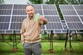 Knowledgeable man showing money he earning by investing in green energy.