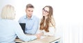 A knowledgeable woman realtor consults with a young couple regarding property acquisition at her office. Selective focus