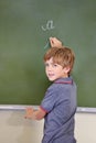 He knows the answer. A young boy writing on the blackboard at school. Royalty Free Stock Photo