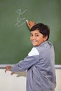 He knows the answer. A young ethnic boy writing on the blackboard at school. Royalty Free Stock Photo